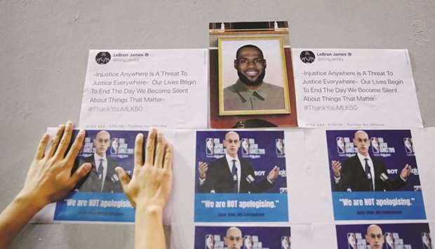 .A protester puts a picture of NBA Commissioner Adam Silver, next to star LeBron Jamesu2019 photo, on a wall during a gathering in support of NBAu2019s Houston Rocketsu2019 team general manager Daryl Morey, who sent a tweet backing the pro-democracy movement, in Hong Kong earlier this week. (Reuters)