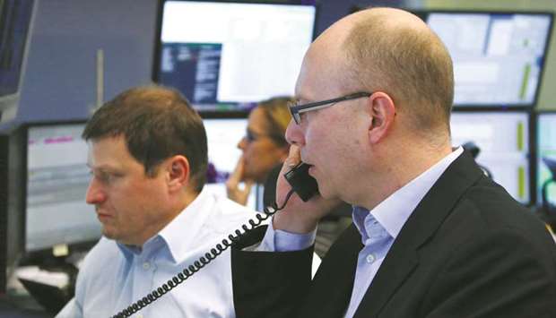 Traders are seen at the Frankfurt Stock Exchange. The DAX 30 lost 0.2% to 12,633.60 points yesterday.