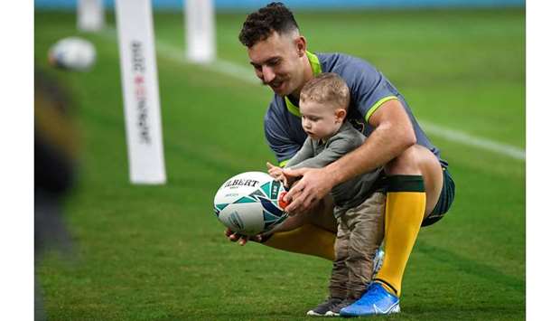 Australiau2019s scrum-half Nic White plays with his son after the Captainu2019s Run session at Oita Stadium in Oita, ahead of the Rugby World Cup quarter-final match against England. (AFP)