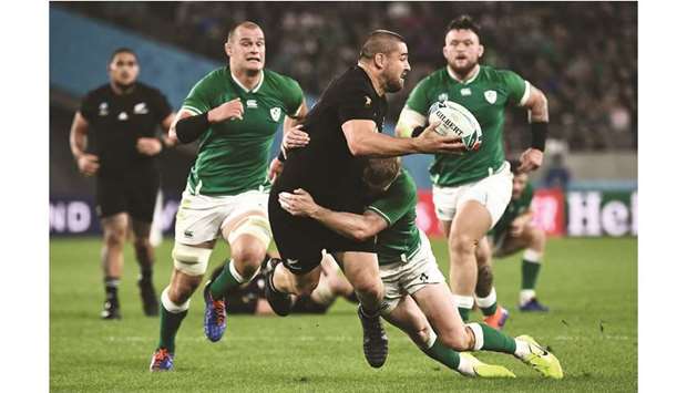New Zealandu2019s hooker Dane Coles (centre) is tackled by Irelandu2019s wing Keith Earls (right) during their quarter-final match at the Tokyo Stadium in Tokyo, Japan, yesterday. (AFP)