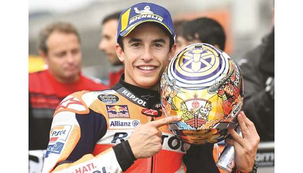 Repsol Honda Team rider Marc Marquez of Spain celebrates his pole position at the parc ferme after the MotoGP qualifying session of the Japanese motorcycle Grand Prix at the Twin Ring Motegi circuit in Motegi, Tochigi prefecture, yesterday.