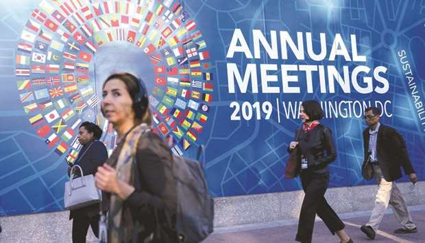 Pedestrians walk past signage for the the International Monetary Fund (IMF) and World Bank Group annual meetings at IMF headquarters in Washington, DC, US, on Tuesday, October 15. PICTURE: Andrew Harrer/Bloomberg