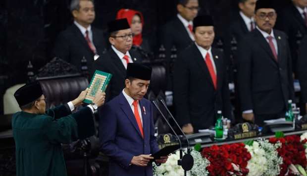 Joko Widodo (front R) takes his oath as Indonesia's President for his second five-year term during an inauguration ceremony at the parliament in Jakarta
