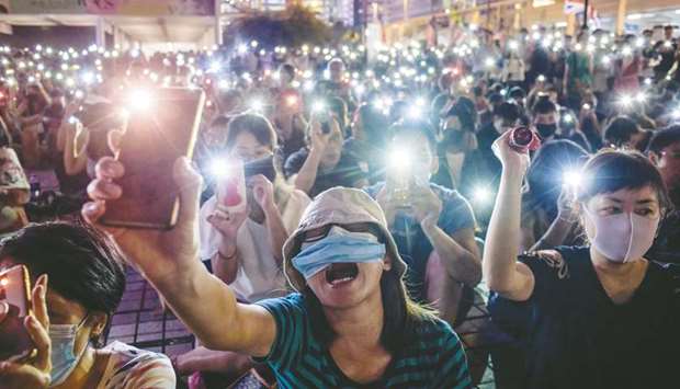 Attendees shout slogans and hold their mobile phones during a rally to show support for pro-democracy protesters in Hong Kong yesterday.