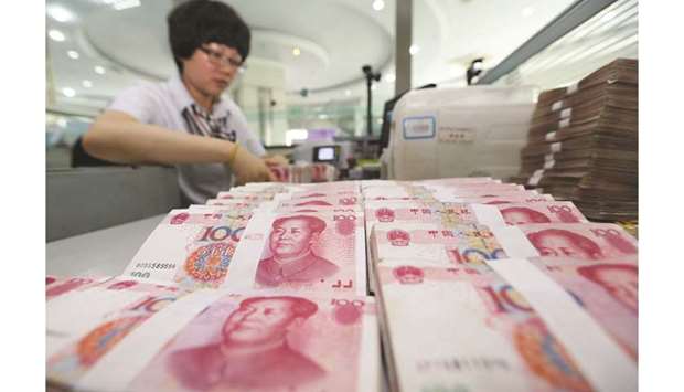 A teller counts yuan banknotes in a bank in Lianyungang, China (file). The Chinese currency fell past the psychologically important level of 7 per dollar in August, prompting the US to name the country a currency manipulator.