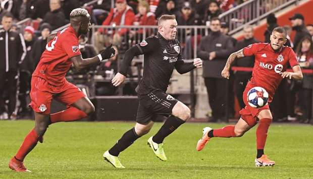 DC United forward Wayne Rooney (centre) is pursued by Toronto FC defender Auro Jr (right) and defender Chris Mavinga at BMO Field on Saturday. PICTURE: Gerry Angus-USA TODAY Sports
