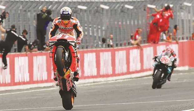 Repsol Hondau2019s Marc Marquez pops a wheelie while crossing the finish line to win the Japanese MotoGP race in Motegi yesterday. (AFP)