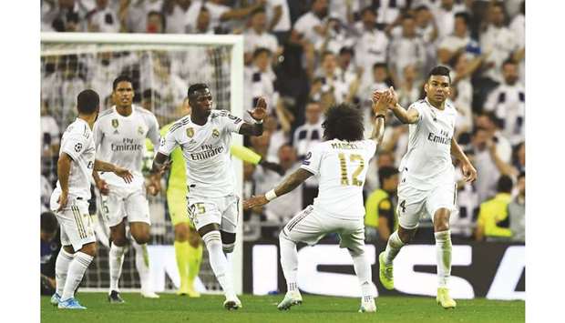 Real Madridu2019s Brazilian midfielder Casemiro (right) celebrates after scoring during the UEFA Champions league Group A match against Club Brugge at the Santiago Bernabeu Stadium in Madrid yesterday. (AFP)