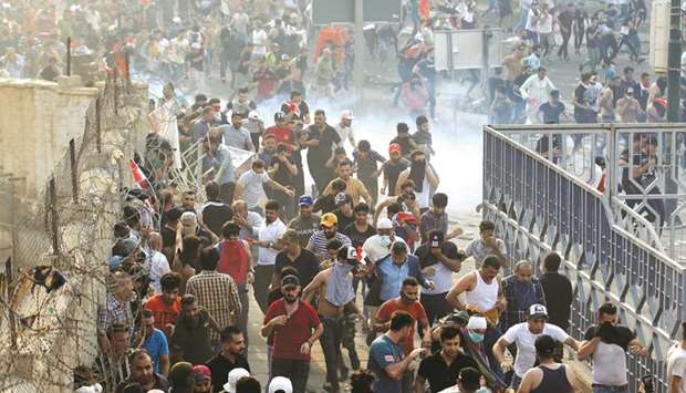 Demonstrators disperse as Iraqi Security forces use tear gas during a protest against corruption amid dissatisfaction at lack of jobs and services at Tahrir square in Baghdad, yesterday.