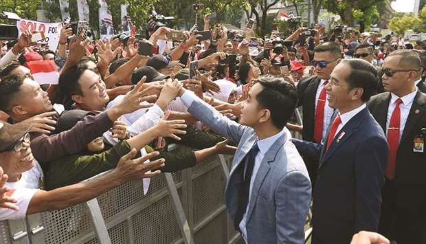 Joko Widodo (second right) and his son Kaesang (third right) meeting a crowd before he was sworn in for a second term as Indonesiau2019s president, in Jakarta yesterday.