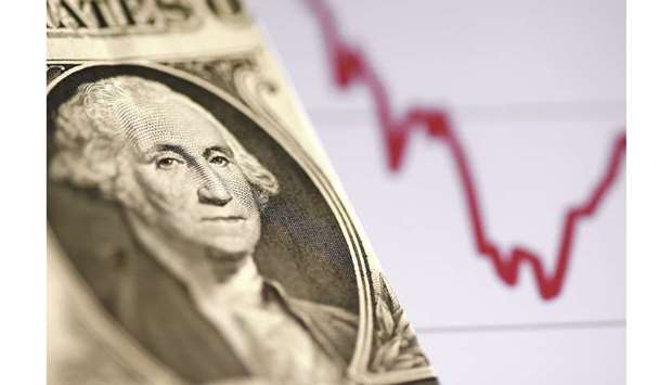 A US dollar note is seen in front of a stock graph in a picture illustration (file). The Bloomberg Dollar Spot Index is down about 2% from a two-year high reached on October 1.