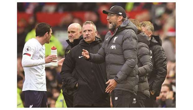 Liverpoolu2019s German manager Jurgen Klopp reacts as fourth official Jonathan Moss (C) looks on during the English Premier League football match between Manchester United and Liverpool at Old Trafford on October 20.