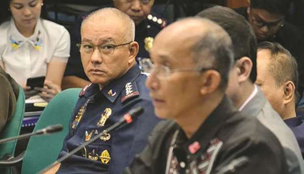 Philippine National Police chief Oscar Albayalde looks at former CIDG chief Benjamin Magalong as he testifies before the Senateu2019s blue ribbon committee which is investigating the recycling of seized illegal drugs.