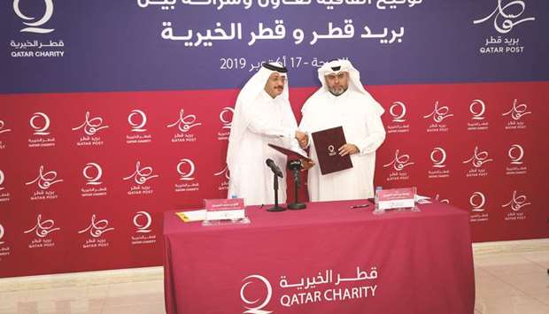 Qatar Postu2019s Faleh Mohamed al-Nuaimi and Qatar Charityu2019s Yousef bin Ahmed al-Kuwari at the agreement signing ceremony.
