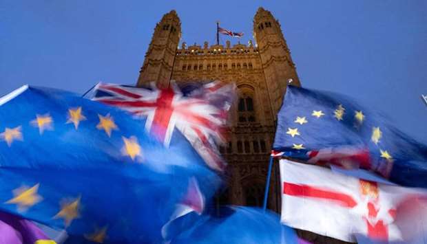 EU and Union flags flutter in the breeze as Pro and anti-Brexit demonstrators protest outside of the Houses of Parliament in central London