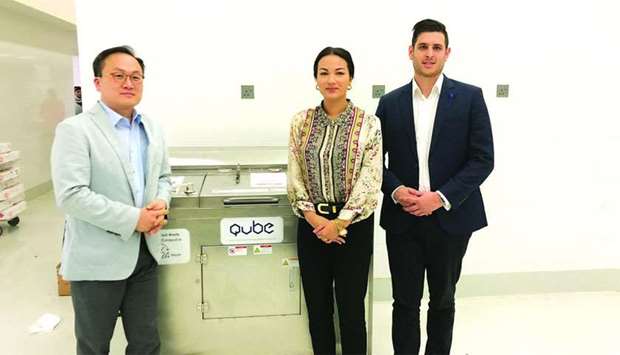 Qatar Upcycling & Biodegradables Enterprise (QUBE) officials with one of the machines that convert food waste into compost. From left: founder and CEO Dae Ho Kim, co-founder and director for marketing & public relations Nodoka Nakamichi, and co-founder and director for maintenance & supervisions Matthew Bridle.