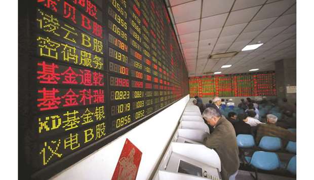 Investors look at computer screens showing stock information at a brokerage house in Shanghai. The Composite index closed up 0.5% to 2,954.38 points yesterday.