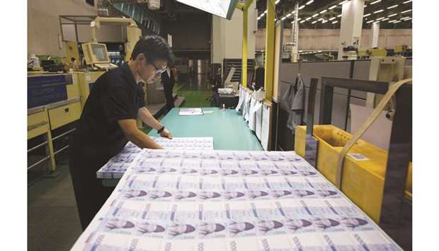 An employee inspects sheets of South Korean 1,000 won banknotes at the Korea Minting, Security Printing & ID Card Operating Corporation factory in Geyongsan, South Korea (file). The won, already the biggest loser among emerging Asian currencies this year, could depreciate by another 4.9% by the end of 2019.