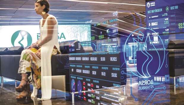 A member of the equities department sits beside digital screens displaying stock price information at the Borsa Istanbul stock exchange in Istanbul (file). The benchmark Borsa Istanbul 100 Index rose 8.6% in September, the most since Januaryu2019s 14% jump.