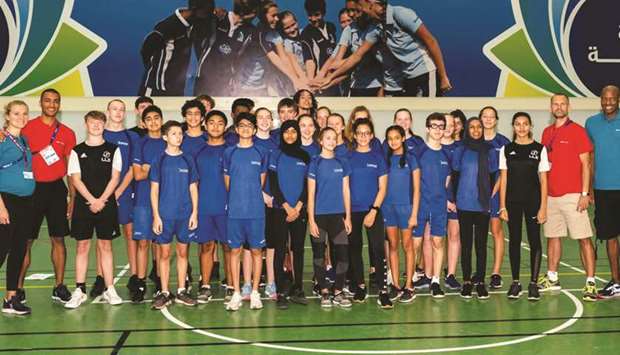 Former heptathlon double-silver medallist Brianne Theisen-Eaton (left), two-time decathlon Olympic champion Ashton Eaton (second from left), long jump world record holder Mike Powell (right) and former high jump world champion Stefan Holm (second from right) pose with kids at Doha College.