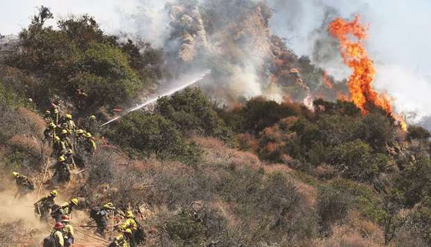 Firefighters battle a wildfire threatening nearby hillside homes in the Pacific Palisades neighbourhood in Los Angeles on Monday.