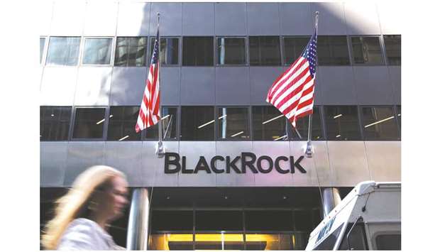 A pedestrian walks past American flags flying at BlackRock headquarters in New York. For BlackRocku2019s high-yield exchange-traded fund, known as HYG, its listed options market has climbed to $34bn in notional outstanding, the firm said; it oversees about $19bn of assets, data compiled by Bloomberg show.