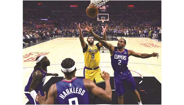 Anthony Davis (centre) of the Los Angeles Lakers and Kawhi Leonard (right) of the LA Clippers reach for a rebound during the NBA game at Staples Center in Los Angeles, United States, on Tuesday. (AFP)