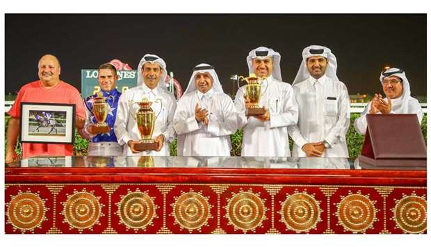 Prominent former jockey Taleb Saeq (centre) and Qatar Racing and Equestrian Club (QREC) Racing manager Abdulla al-Kubaisi (right) with the winners of the Owners Cup after Al Shahania Studu2019s Rajeh won the 1900m feature at Al Rayyan Park yesterday. PICTURES: Juhaim