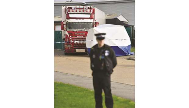 A police officer secures the cordon at the scene where the lorry was discovered at Waterglade Industrial Park in Grays, east of London, yesterday.