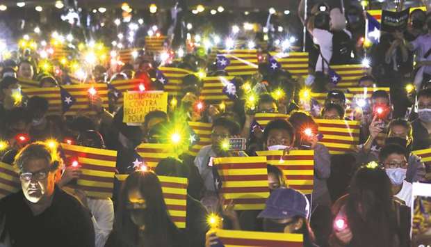 Pro-democracy demonstrators hold Esteladas (Catalan separatist flag) and flashlights during a protest in Hong Kongu2019s Chater Garden yesterday to show their solidarity with the Catalonian independence movement in Spain, in Hong Kong.