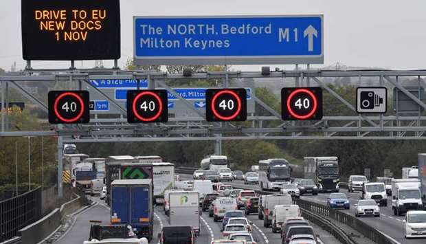 Traffic is seen passing government Brexit information campaign signs on the M1 motorway near Milton Keynes, Britain