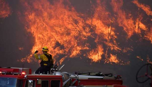 Firefighters battle a wind driven wildfire in the hills of Canyon Country north of Los Angeles, California