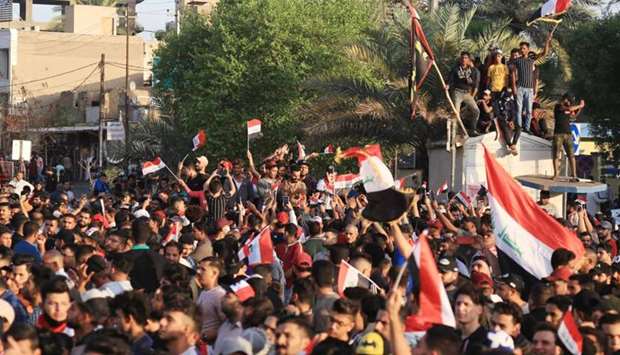 Iraqi protestors wave national flags during an anti-government demonstration in the city of Karbala, south of Iraq's capital Baghdad
