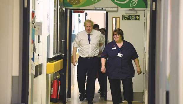 Prime Minister Boris Johnson arrives at the childrenu2019s ward with chief nurse Nicola Burns-Muir as he visits Milton Keynes University Hospital in Buckinghamshire, Britain, yesterday.
