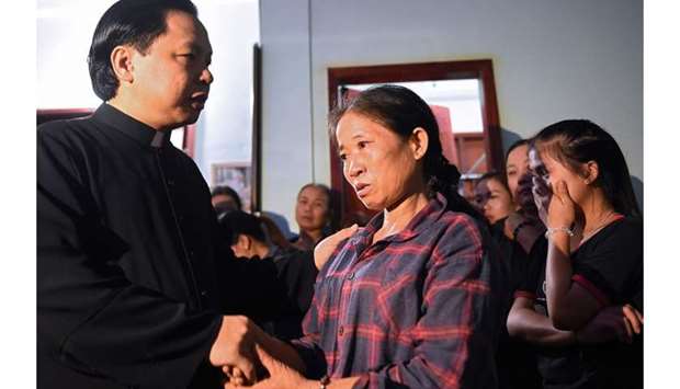 Tran Thi Hien (C), mother of Bui Thi Nhung, who is feared to be among the 39 people found dead in a truck in Britain, is consoled inside her house in Vietnam's Nghe An province