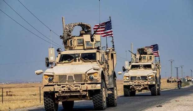 US military vehicles, part of a convoy arriving from northern Iraq, drive through the countryside of Syria's northeastern city of Qamishli
