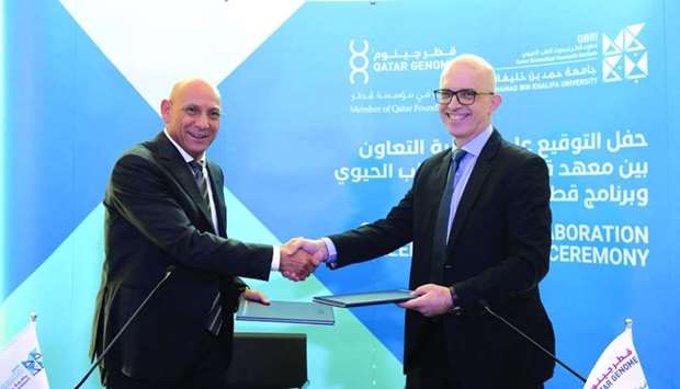 Dr Omar El Agnaf, executive director of QBRI, and Dr Said Ismail, Qatar Genome director, shake hands after signing the agreement.