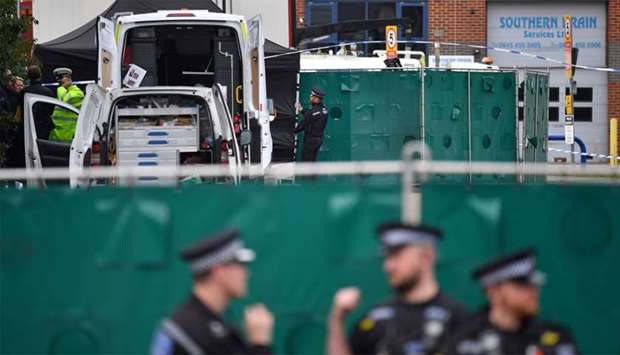 British Police officers work near a lorry, believed to have originated from Bulgaria, and found to be containing 39 dead bodies, inside a police cordon at Waterglade Industrial Park in Grays, east of London