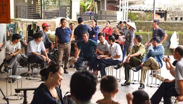 Villagers and local police personnel gather at the house of 18-year old Hoang Van Tiep who is feared to be among the 39 people found dead in a truck in Britain
