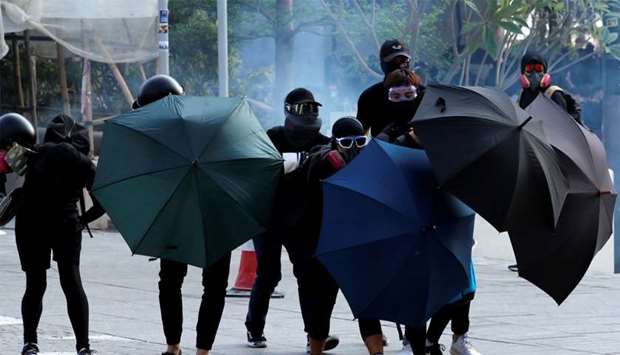 Anti-government demonstrators take cover under umbrellas during a protest in Hong Kong