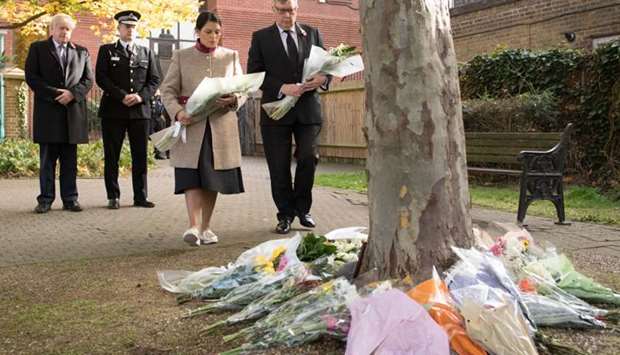 Britain's Prime Minister Boris Johnson (L) stands with with Chief Constable of Essex Police, Ben-Julian Harrington (2L), as Britain's Home Secretary Priti Patel (3L) lays flowers during a visit to Thurrock Council Offices in Thurrock, east of London, following the October 23 discovery of 39 bodies concealed in a lorry.