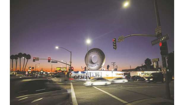 Randyu2019s Donuts stands as vehicles drive down La Cienega Boulevard at night in Inglewood, California. In a filing with the US Court of Appeals for the District of Columbia, major automakers and the National a Dealers Association said they backed the administration bid to bar individual emissions rules by states.