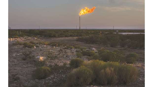A gas flare burns at dusk in the Permian Basin in Texas (file). In almost a year, an exchange-traded fund that tracks oil drillers has lost half its value, shale production growth has slowed, funding has gotten scarce and more than two dozen companies have collapsed into bankruptcy.