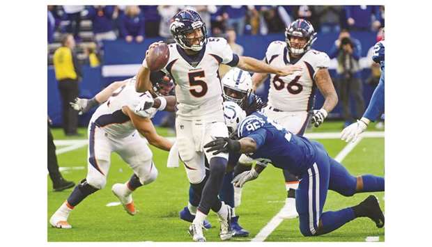 Denver Broncos quarterback Joe Flacco (left) throws away the ball as he is pressured by the Indianapolis Colts defense during the NFL game in Indianapolis, United States, on Sunday. (USA TODAY Sports)
