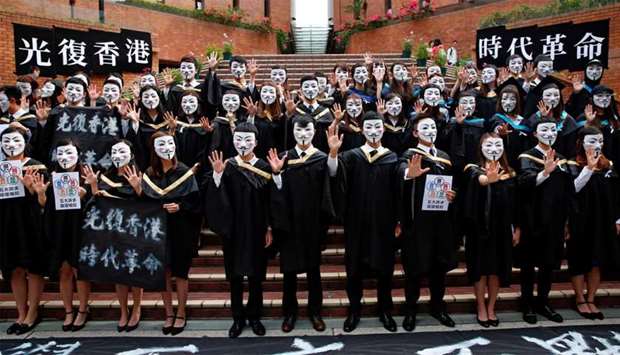 University students wearing Guy Fawkes masks pose for a photoshoot of a graduation ceremony to support anti-government protests at the Hong Kong Polytechnic University, in Hong Kong