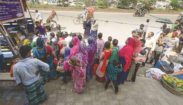 People stand in a line to purchase subsidised onions in Dhaka yesterday.