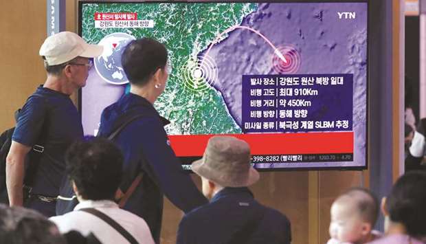 People watch a television news report on North Korea firing a missile that is believed to be launched from a submarine, in Seoul, South Korea, yesterday.