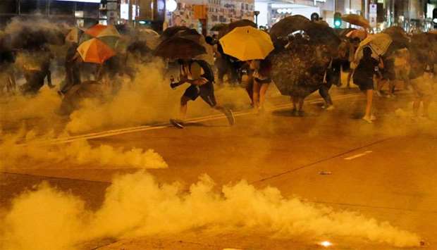 Protesters run away from tear gas during a demonstration at Taikoo station in Hong Kong