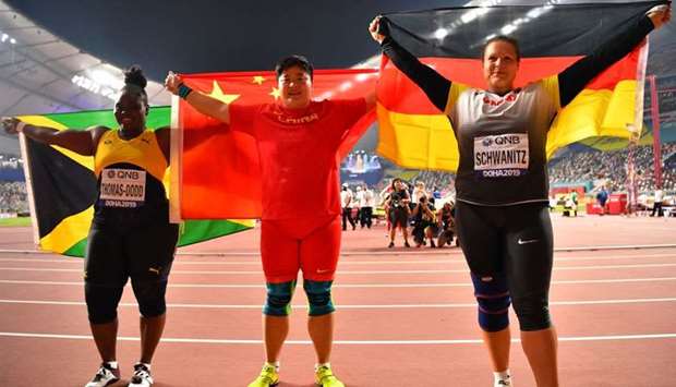Gold medalist China's Lijiao Gong, silver medalist Jamaica's Danniel Thomas-Dodd and bronze medalist Germany's Christina Schwanitz pose after the Women's Shot Put Final at Khalifa International Stadium, Doha