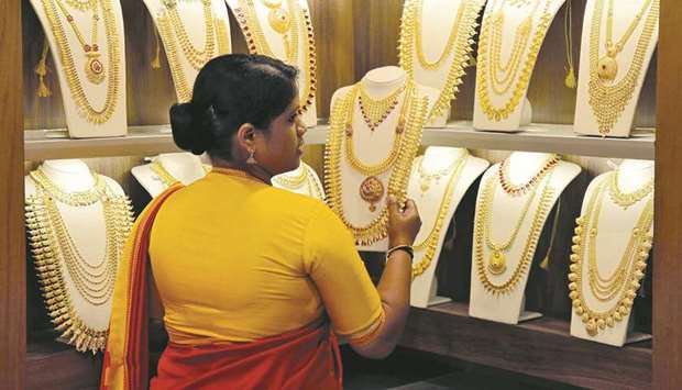 A saleswoman picks gold necklaces to show to a customer inside a jewellery showroom in Kochi. Indiau2019s gold imports plunged 68% year-on-year in September to their lowest in over three years as record domestic prices curbed retail buying, a government source said yesterday.